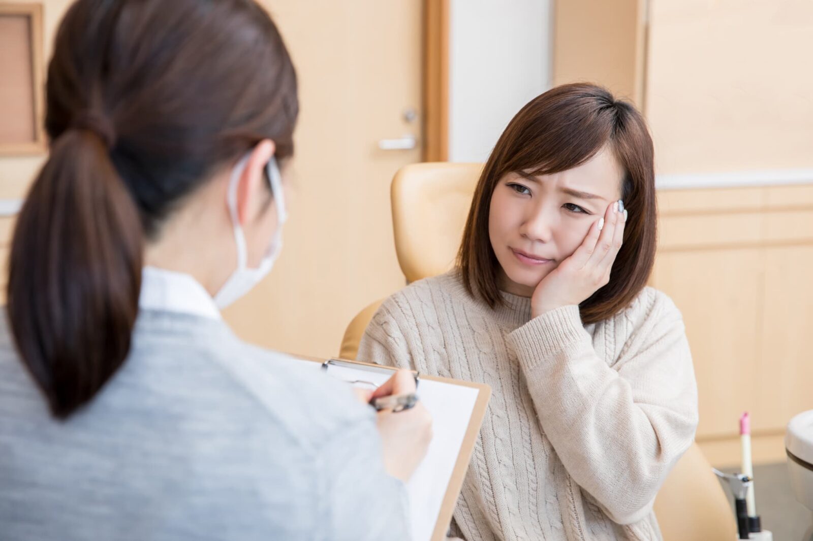 虫歯が痛くて歯医者を受診する女性
