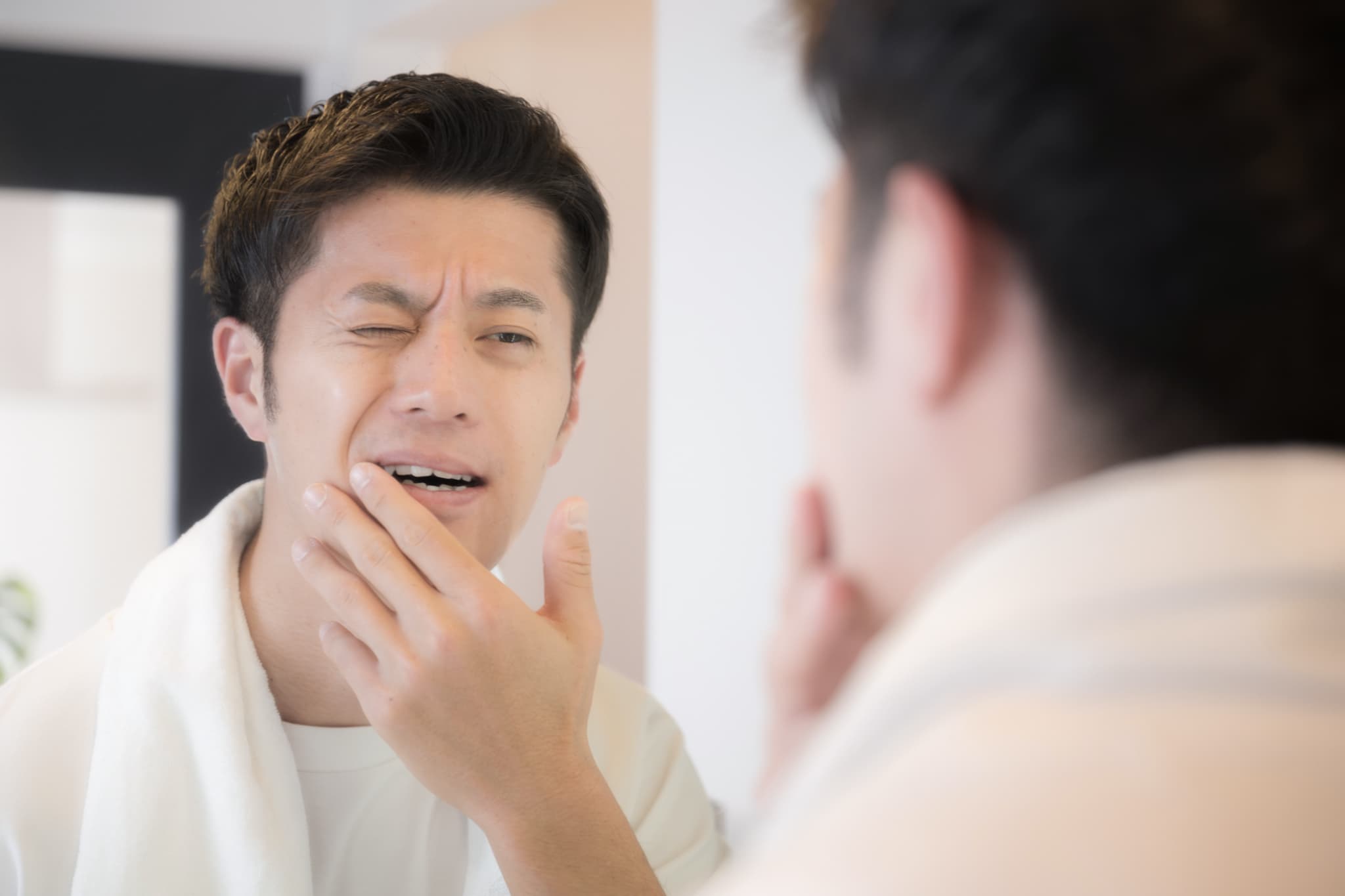 ワイヤー矯正中に歯が痛い男性